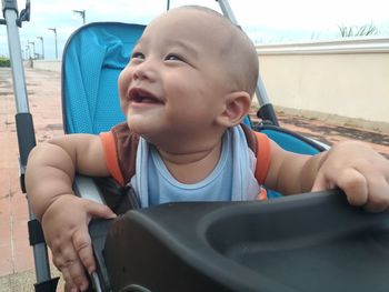 Smiling baby boy sitting in stroller