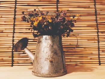 Close-up of flower vase on table against wall