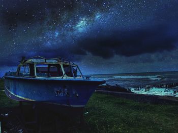 Boat moored on sea against sky at night