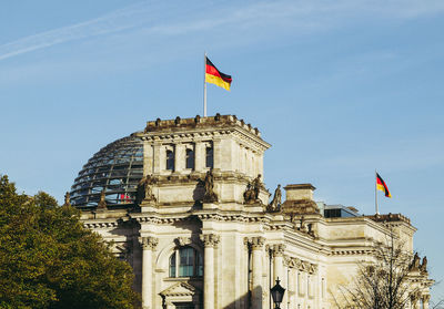 Low angle view of flags in city against sky