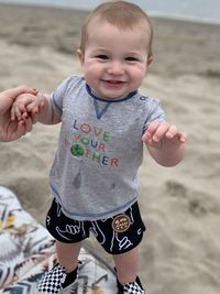 Portrait of cute girl playing with sand at beach