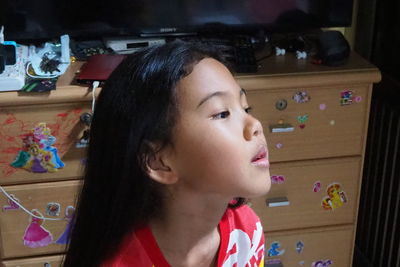 Portrait of cute girl looking away at home
