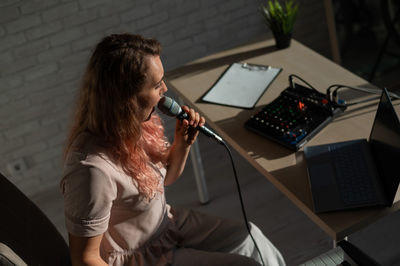 Young woman using mobile phone while sitting in office