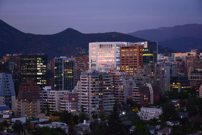 Buildings in city against sky at dusk