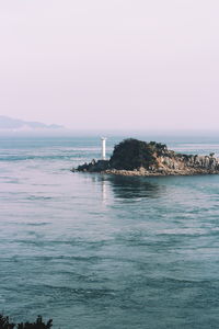 Scenic view of sea by buildings against sky