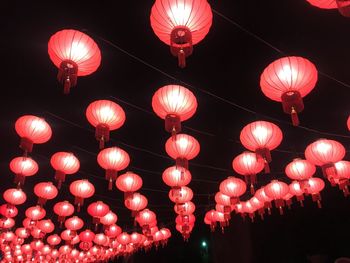 Low angle view of illuminated lanterns hanging at night