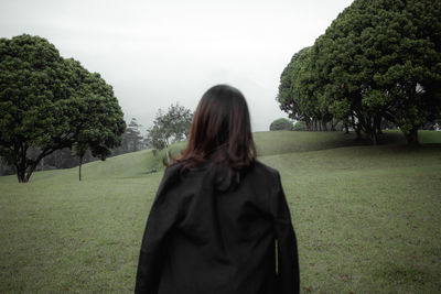 Rear view of woman standing on field