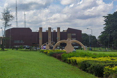 Park by buildings in city against sky