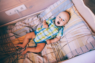 High angle view of baby girl lying on couch