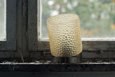 Close-up of rusty glass against window