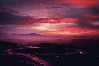 High angle view of illuminated cityscape against sky during sunset