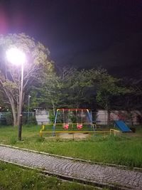 Illuminated soccer field against sky at night