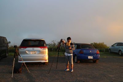 People photographing cars on road at night