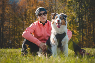 Candid portrait of female athlete with her running and hiking partner, an australian shepherd dog