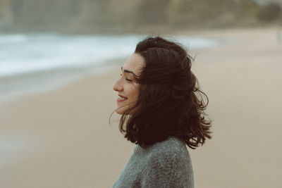 Side view of smiling young woman looking away