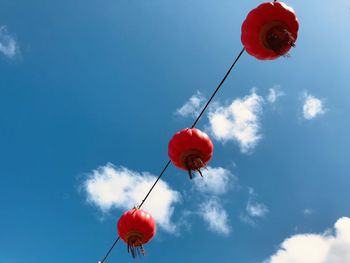 Low angle view of red balloons against sky