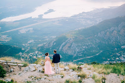 Rear view of couple walking on mountain
