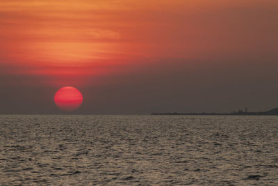 Scenic view of sea against orange sky