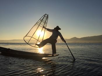 People in sea at sunset