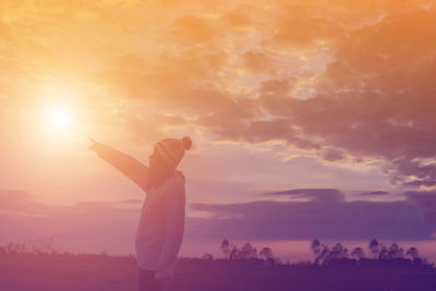 Silhouette person standing against sky during sunset