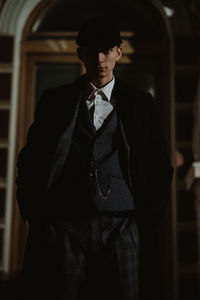 Portrait of young man standing at home