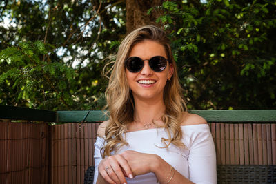 Portrait of smiling young woman wearing sunglasses