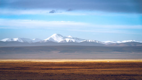 The snow-capped mountains beyond the road