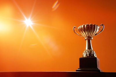 Low angle view of trophy against yellow background