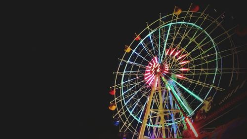 Low angle view of ferris wheel at night