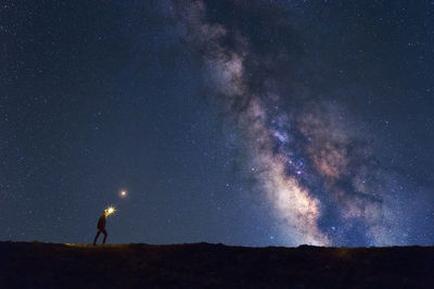 Full length of man standing against star field at night