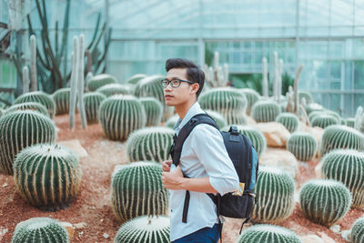 Full length of young man standing by plants