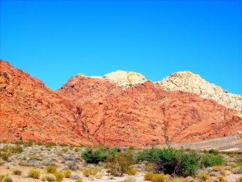 Low angle view of rock formation against clear blue sky