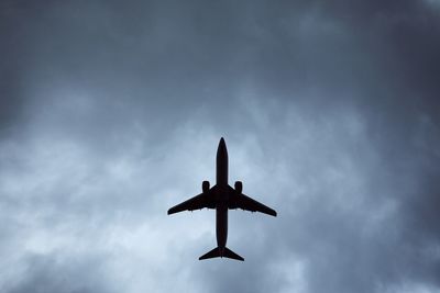 Plane in dramatic cloud. low angle view of airplane during landing in wind storm.