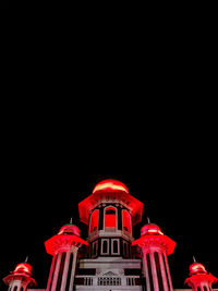 Low angle view of illuminated building against sky at night