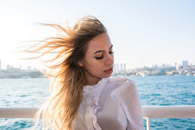 Young woman looking at sea against sky