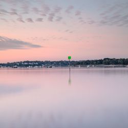 Scenic view of lake against sky at sunset