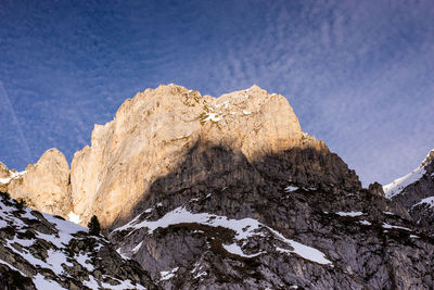 Low angle view of snowcapped mountain against sky