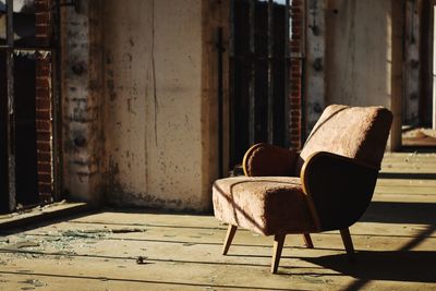 Armchair in abandoned house floor during sunny day