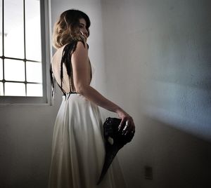 Portrait of young woman standing at home