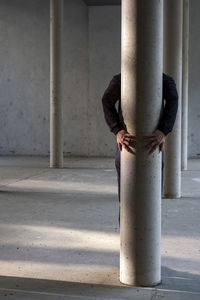 Midsection of man standing on pole against building