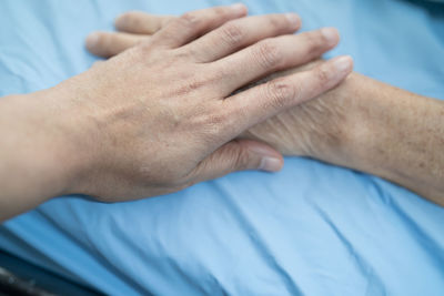 Close-up of hands on bed