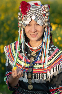 Portrait of smiling woman in traditional clothing standing at farm
