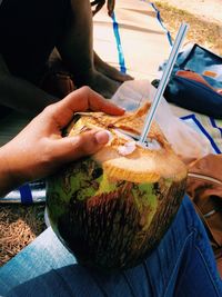 Close-up of man holding coconut