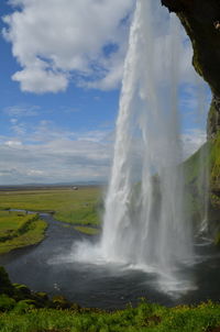 Scenic view of waterfall against sky