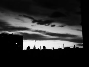 Silhouette buildings against sky at dusk