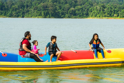 People sitting on water sled at lake