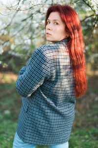 Portrait of young woman standing in forest