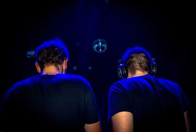 Rear view of men standing in nightclub