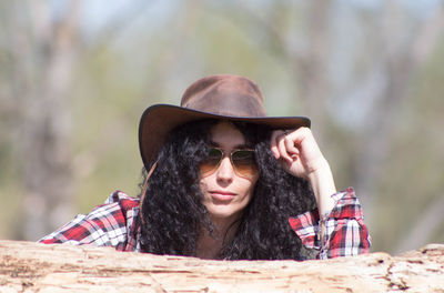 Portrait of woman wearing hat and sunglasses in sunny day