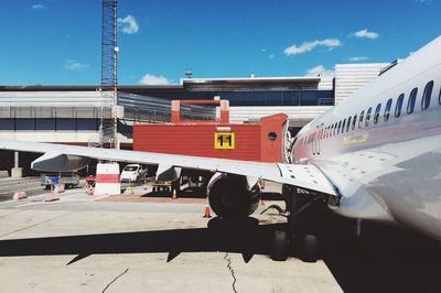 Airplane on airport runway against sky